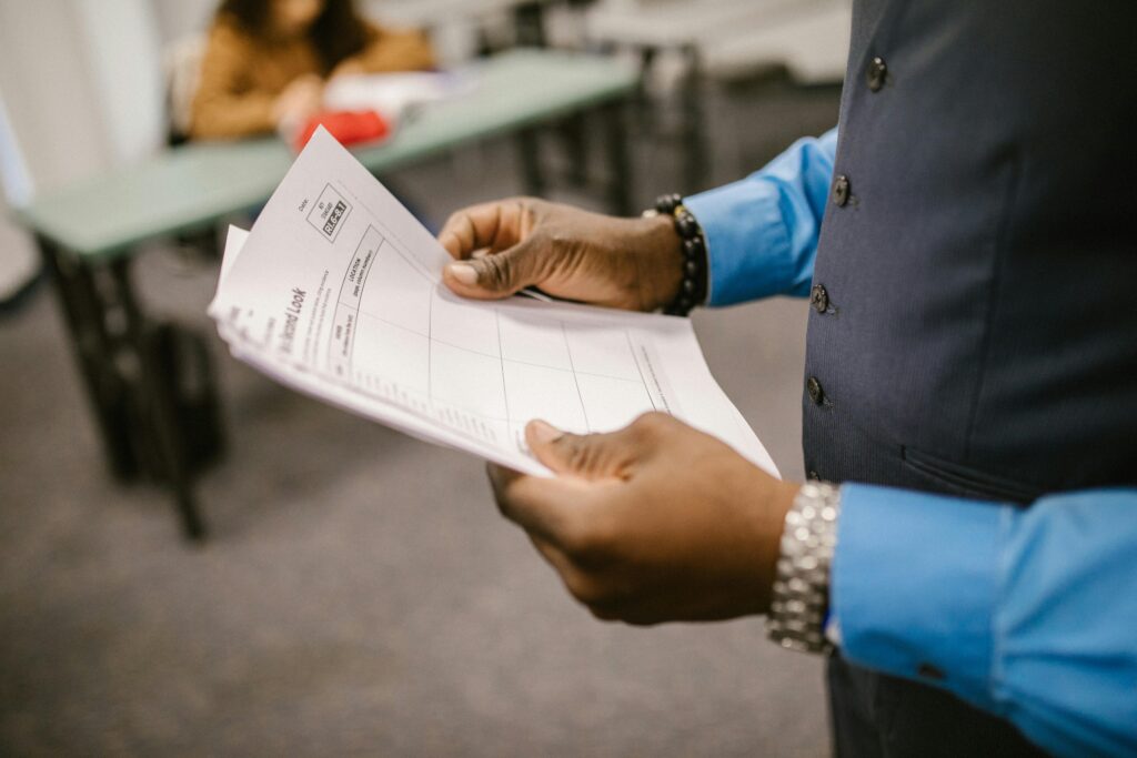 pexels photo 7092345 7092345 1 An instructor examining test papers in a classroom setting, focusing on education and evaluation.
